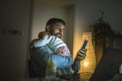 Young father working at home with his baby girl