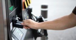 a man putting a credit card into a gas pump