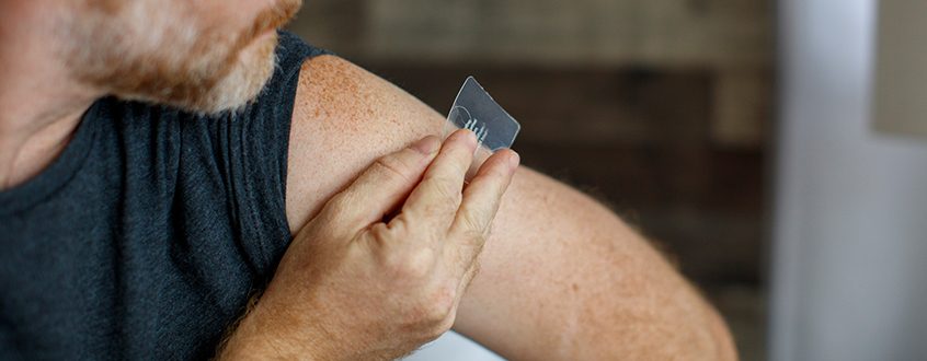 Man placing a patch on his arm