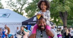 A daughter sitting on her fathers shoulders