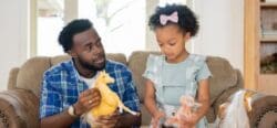 A father and daughter playing with toy horses