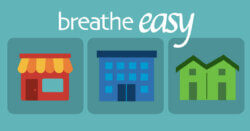 "Breathe Easy" above three illustrated buildings: a shop with a striped awning, a multi-story office building and a pair of townhomes.