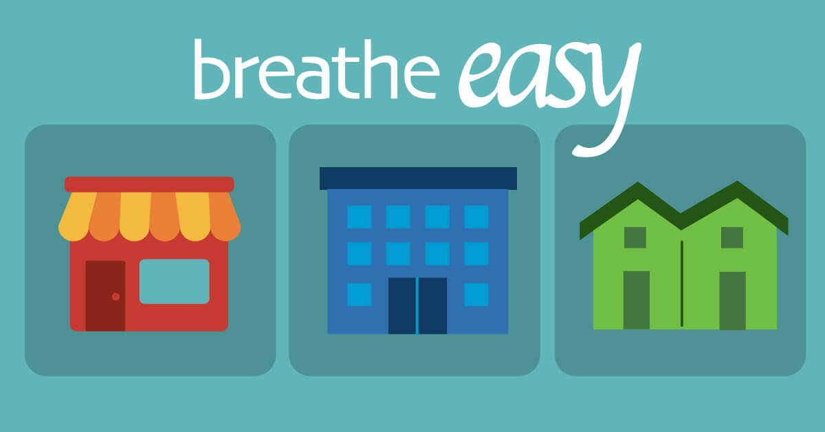 "Breathe Easy" above three illustrated buildings: a shop with a striped awning, a multi-story office building and a pair of townhomes.